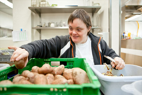 Eine Frau schält Kartoffeln