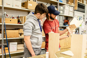 Zwei Männer arbeiten mit einem Stück Holz in der Werkstatt
