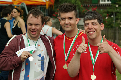Drei Männer zeigen stolz ihre Medaillen, die sie gewonnen haben