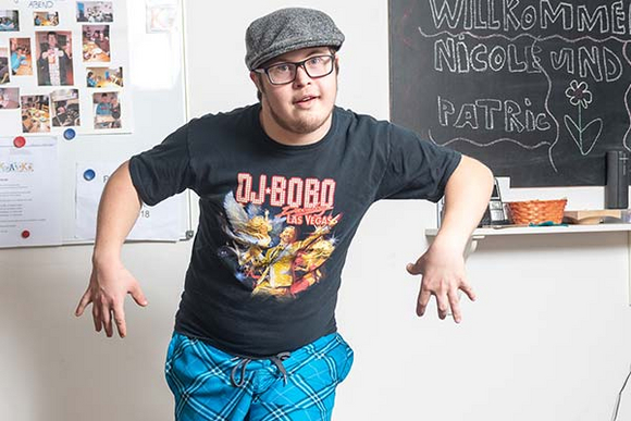 Junger Mann mit DJ-Bobo-T-shirt beim Tanzen in der Wohnung