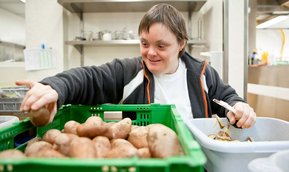 Eine Mitarbeiterin der Küche beim Kartoffeln schälen